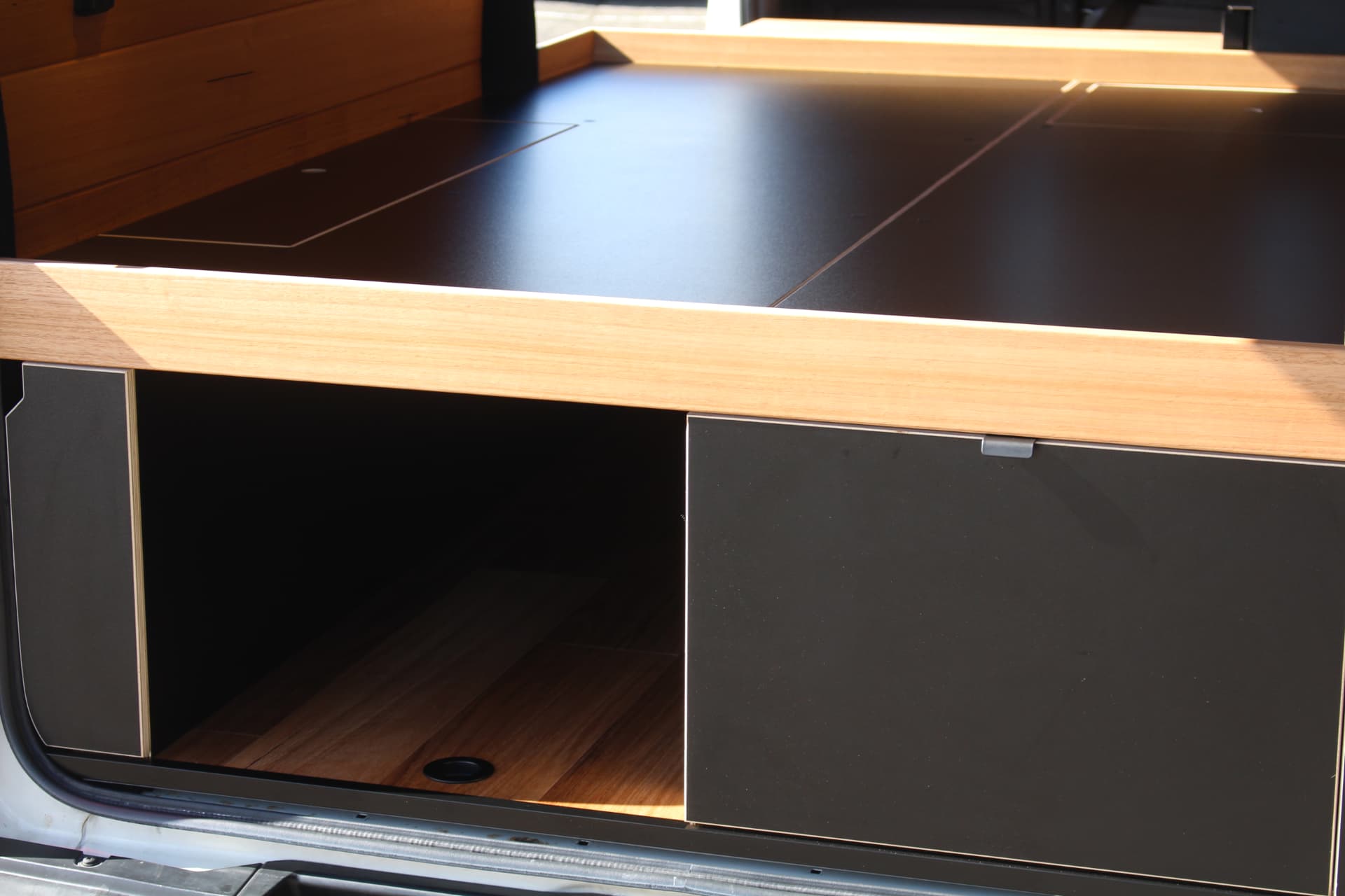 Hiace 200 Series Weekender — Bed platform, benchtop and storage in afternoon light