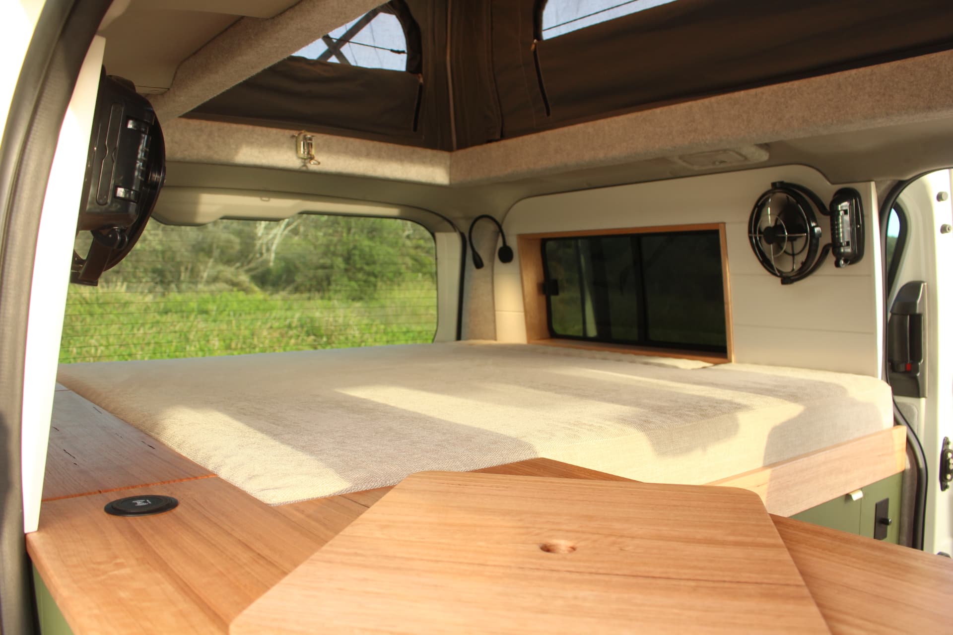 Toyota Hiace 300 Series — Bed made up with the pop top open above