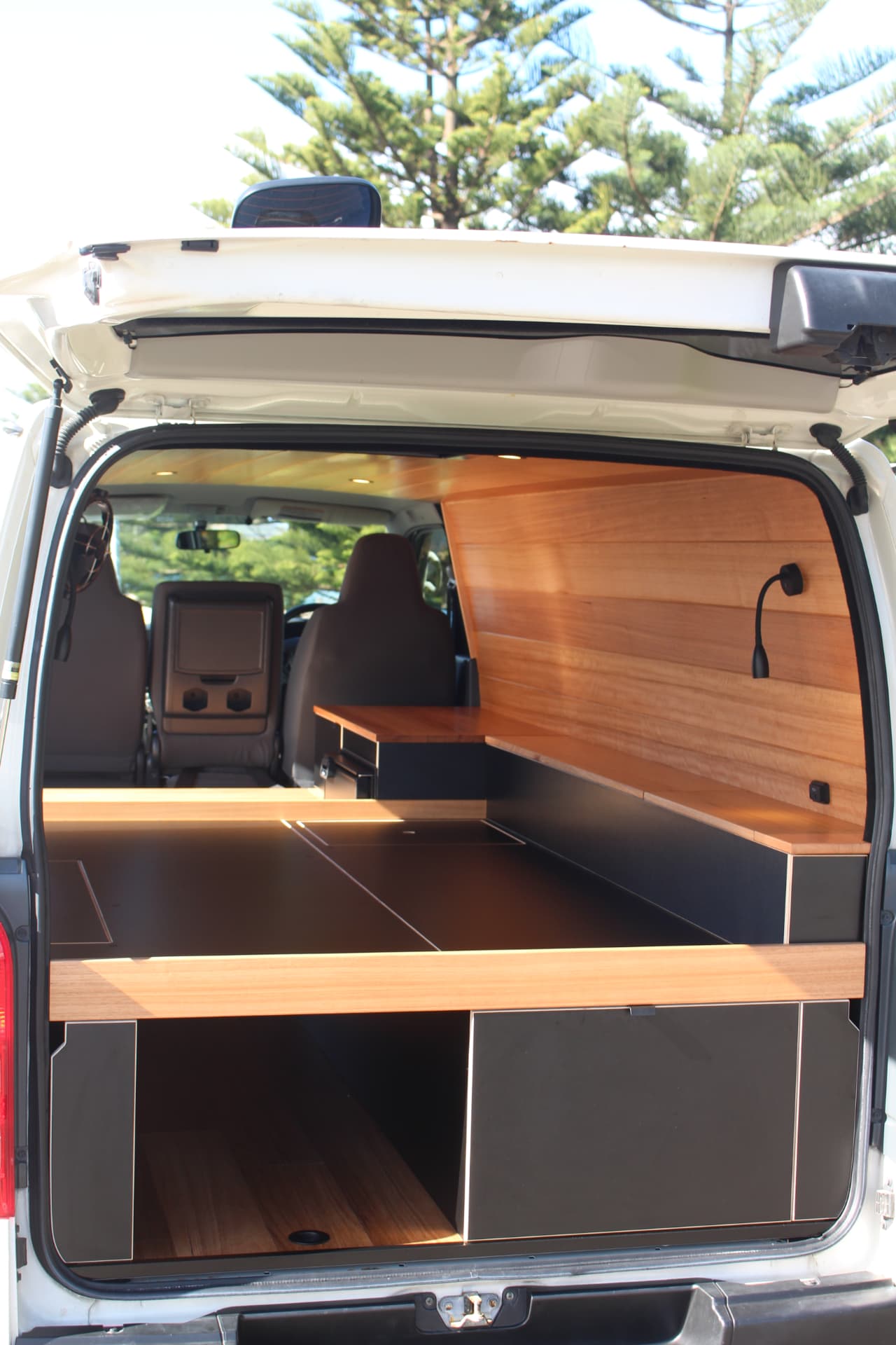 Hiace 200 Series Weekender — Rear hatch open on the full timber and black interior