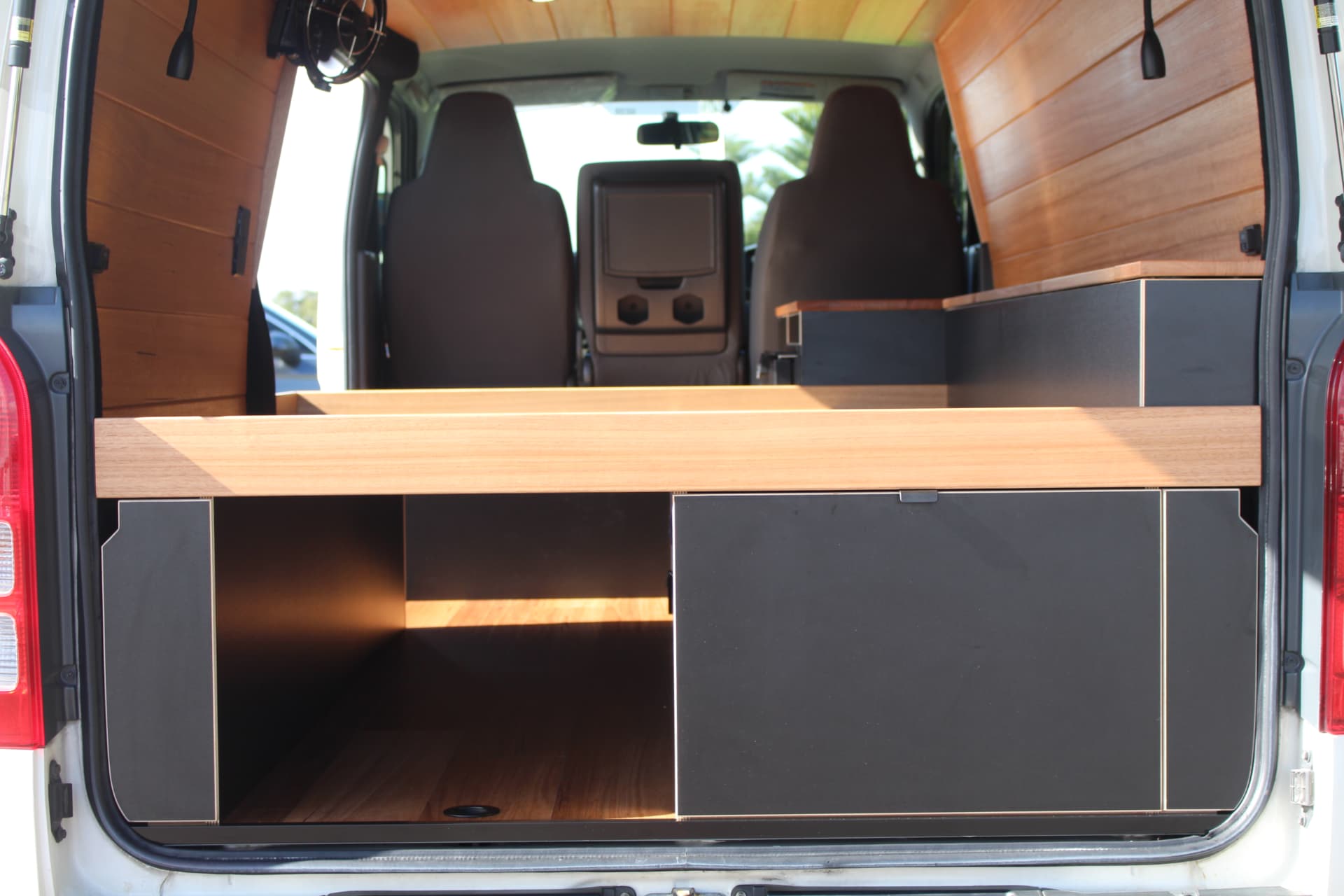 Hiace 200 Series Weekender — Bed platform and storage seen from the rear