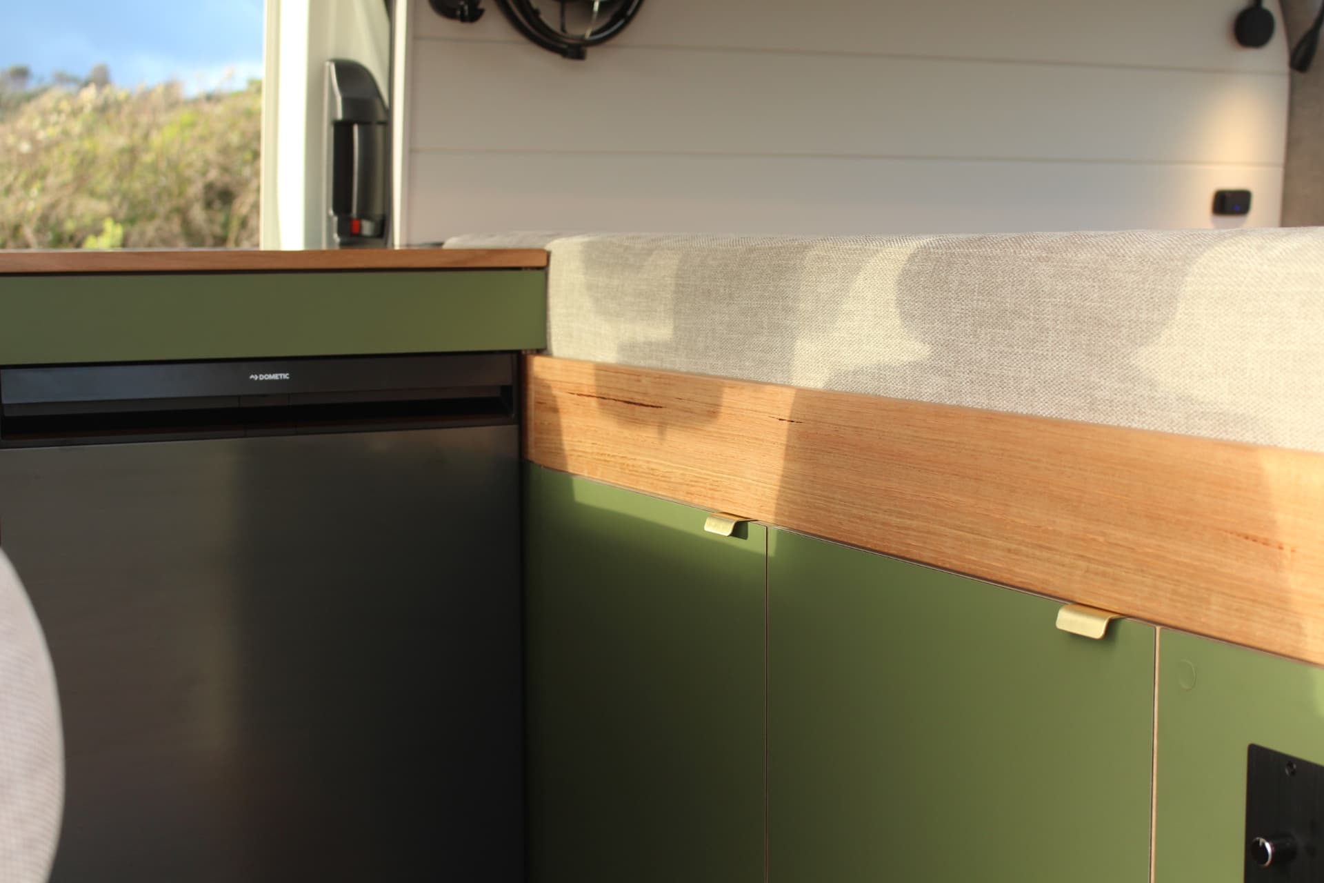 Toyota Hiace 300 Series — Dometic fridge tucked beside the bed platform