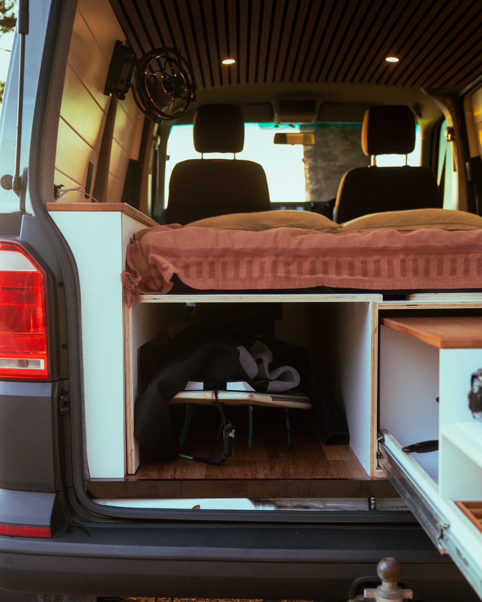 VW Transporter — Wetsuit and board stowed in the garage under the bed
