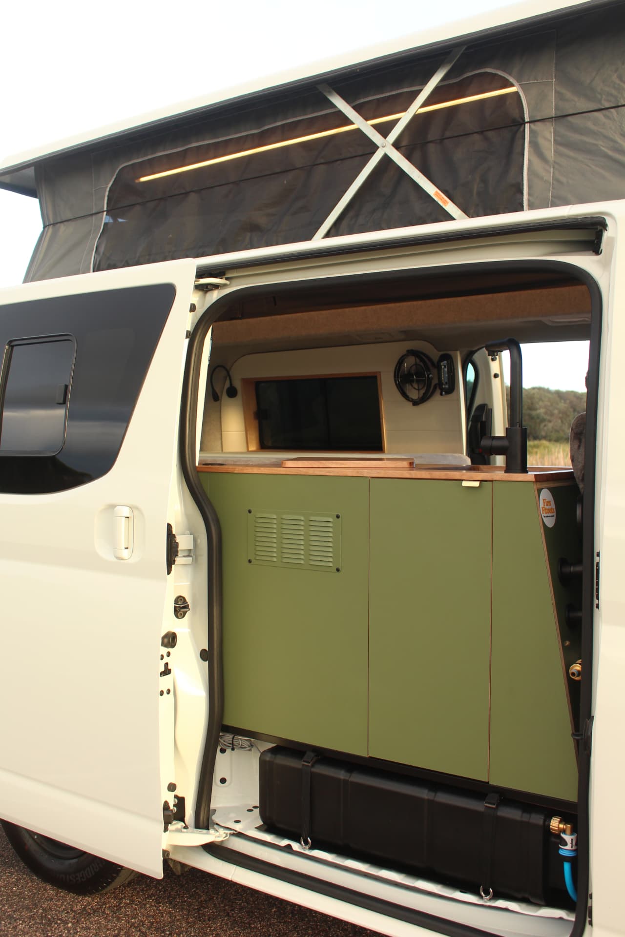 Toyota Hiace 300 Series — Side door open on the olive kitchen and pop top