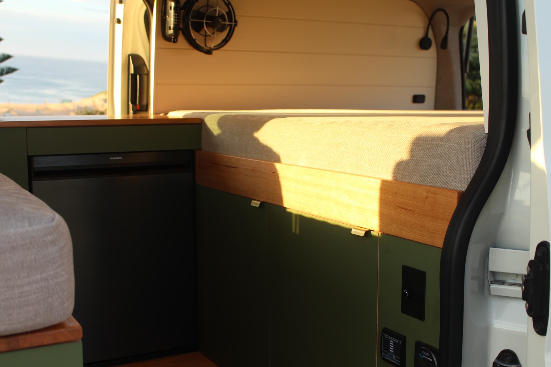 Olive cabinetry and timber bed platform with ocean view