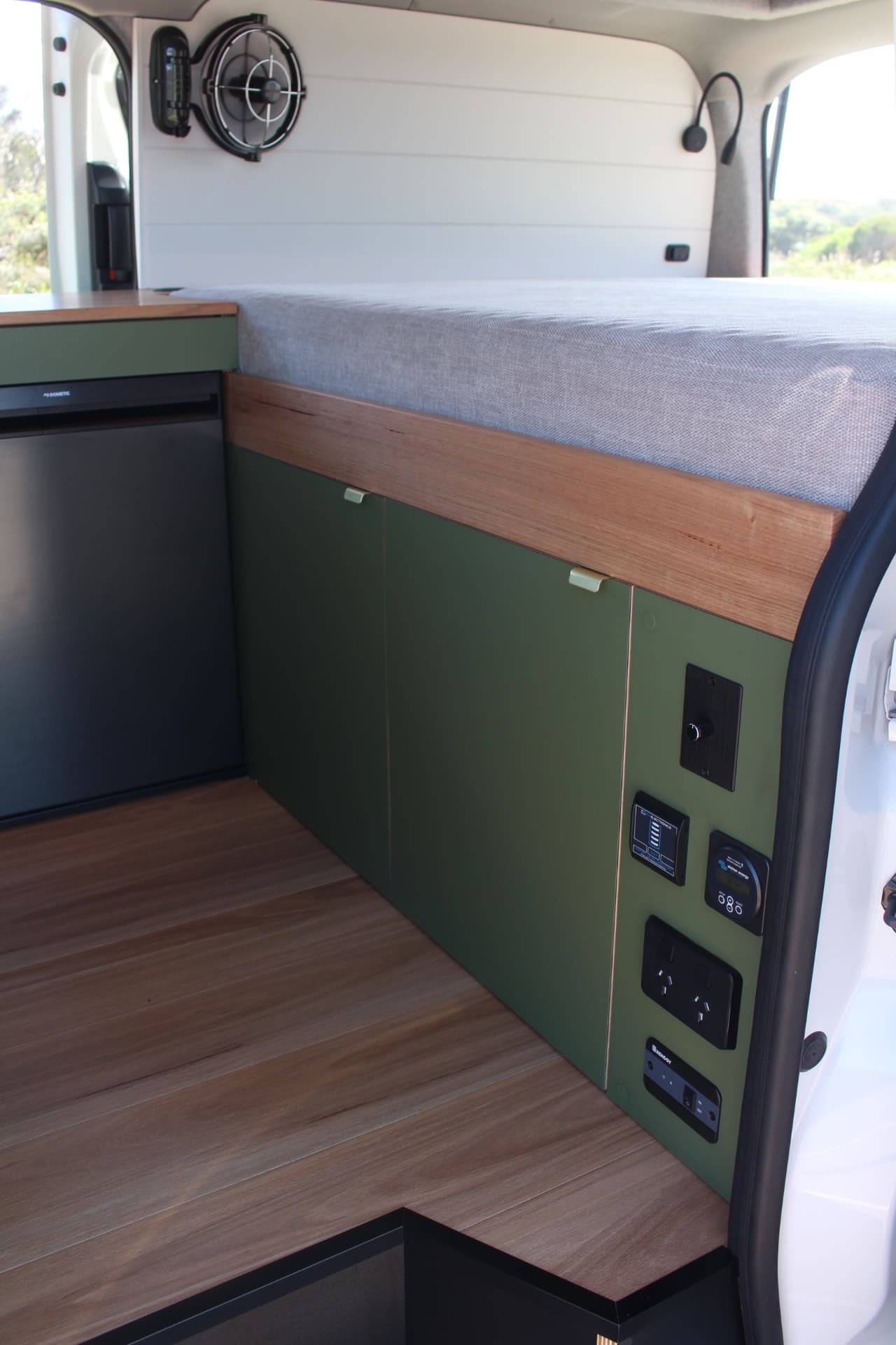 Toyota Hiace 300 Series — Timber floor, olive doors and switchboard from the side door