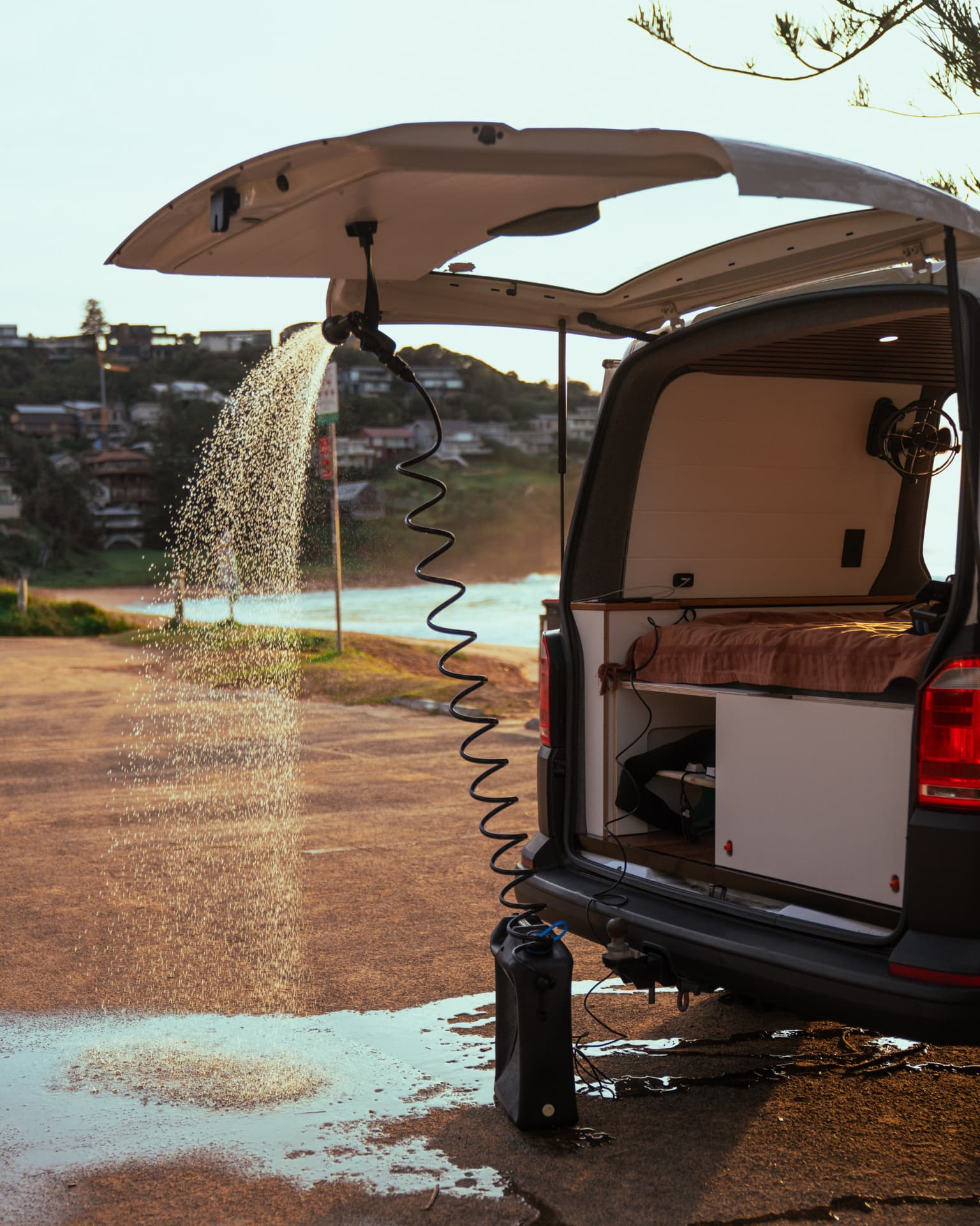 VW Transporter — Shower arcing out over the headland at sunrise